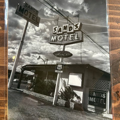 Black and white photo of Sands Motel with multiple signs on a wooden frame.