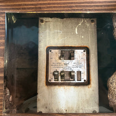Rust-covered electronic panel with visible wear on a wooden surface