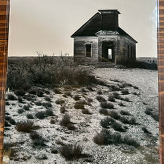 Black and white photograph of a small building on a textured surface