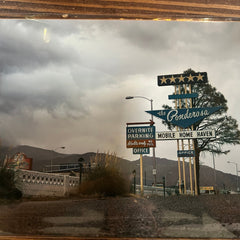 Collection of vintage signs on a wooden surface with a mountainous background