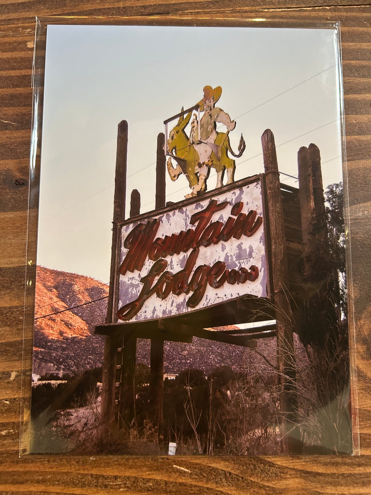 Decorative metal sign with text and figures on a wooden surface