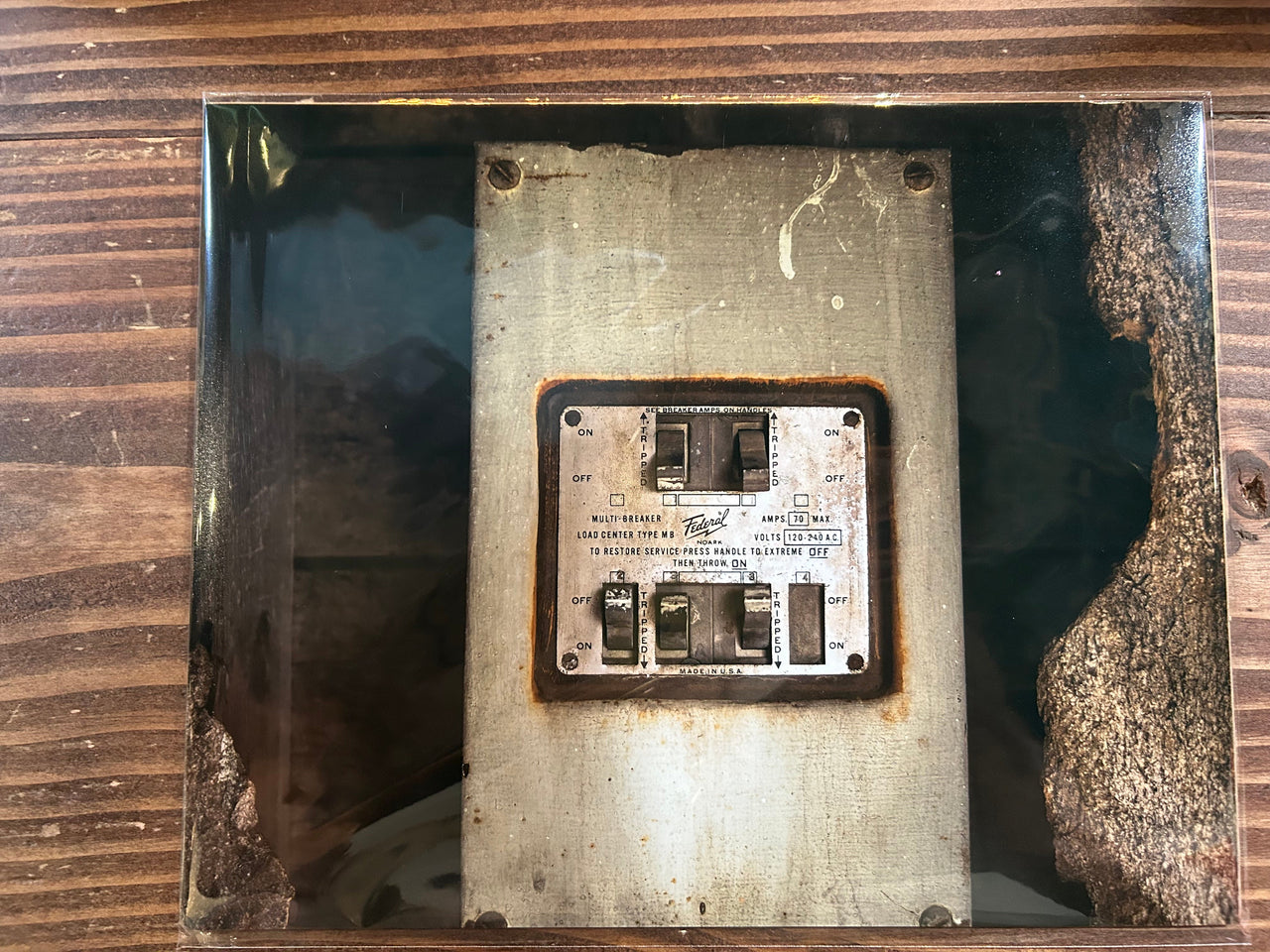 Rust-covered electronic panel with visible wear on a wooden surface