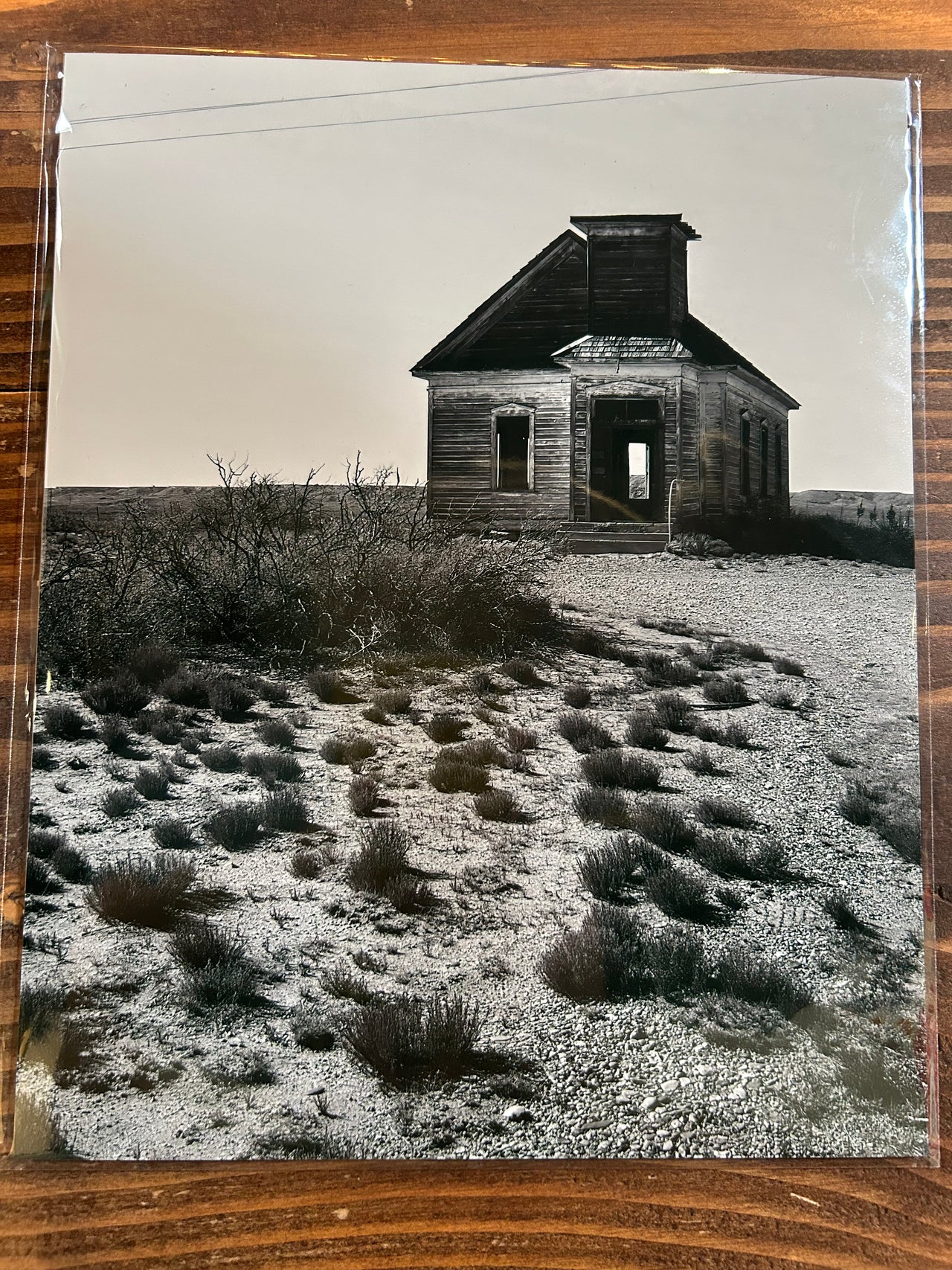 Black and white photograph of a small building on a textured surface