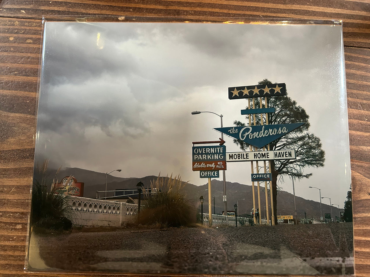 Collection of vintage signs on a wooden surface with a mountainous background